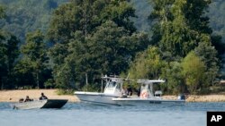 Petugas berpatroli di sekitar kapal terbalik, Jumat malam, 20 Juli 2018, yang mengakibatkan sedikitnya 13 tewas di Table Rock Lake, Branson, Missouri.(Foto AP / Charlie Riedel).