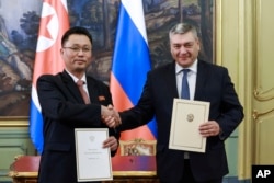 FILE - Russian Deputy Foreign Minister Andrei Rudenko and North Korean Vice Foreign Minister Kim Jong Gyu display a protocol on ratification of a partnership between their countries, in Moscow, Dec. 4, 2024. (Russian Foreign Ministry Press Service via AP)