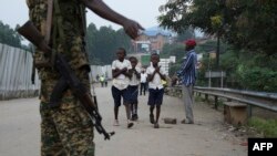 FILE - School-going pupils from the Democratic Republic of Congo cross the Mpondwe border point separating Uganda and the DRC, Aug. 14, 2019. 