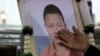 A relative touches a portrait of a victim of a school bus fire at Wat Khao Phraya Sangkharam School Lan Sak, Uthai Thani province, Thailand, Oct. 3, 2024. 