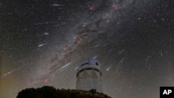 This Dec. 14, 2023 image made available by NOIRLab shows meteors from the Geminid meteor shower streaking across the sky above the Nicholas U. Mayall Telescope at Kitt Peak National Observatory (KPNO), a Program of NSF's NOIRLab, in Tucson, Ariz. 