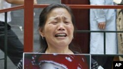 一名婦女2009年5月8日在北京衛生部前舉著因食用毒奶粉而死亡的孫女照片，要求當局伸張正義。