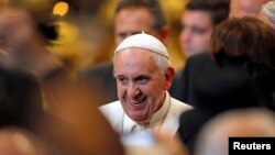 Pope Francis smiles as he leaves after an audience with Italian athletes in St. Peter's Basilica at the Vatican, Dec.19, 2014.