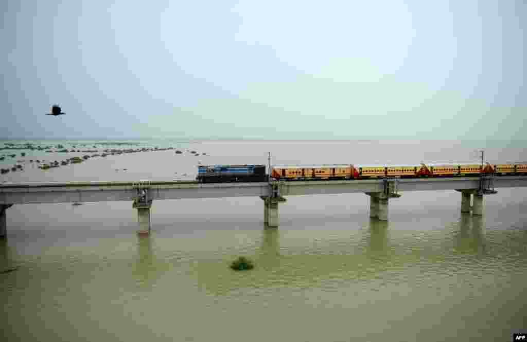 A train crosses a bridge over the flooded River Gange, as water levels in the Gange and Yamuna rivers rise, in Allahabad, India.