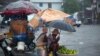 Los vendedores ambulantes se protegen de la lluvia de la tormenta tropical Laura en Puerto Príncipe, Haití, el domingo 23 de agosto de 2020. 