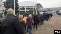 Ljudi čekaju u redu za vakcinaciju i revakcinaciju ispred hale Begradskoj sajma, u Beogradu, 20. februara 2021. (Foto: Jovana Đurović, VoA)