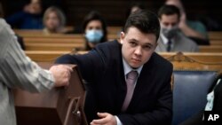 Kyle Rittenhouse pulls numbers of jurors out of a tumbler during his trial at the Kenosha County Courthouse in Kenosha, Wisconsin, Nov. 16, 2021.