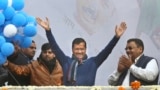 Incumbent Delhi Chief Minister Arvind Kejriwal, center, waves at Aam Aadmi Party, or "common man's" party headquarters as they celebrate the party's victory in New Delhi, India, Feb. 11, 2020. 