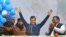 Incumbent Delhi Chief Minister Arvind Kejriwal, center, waves at Aam Aadmi Party, or "common man's" party headquarters as they celebrate the party's victory in New Delhi, India, Feb. 11, 2020. 