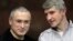 Mikhail Khodorkovsky, left, and his co-defendant Platon Lebedev talk behind a glass enclosure at a court room in Moscow, Russia, Dec. 30, 2010. 