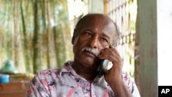 Arobinda Mohalder talks on a phone from his relative's residence after his house was burnt down by a mob, in Dhaka, Bangladesh, Aug. 11, 2024.