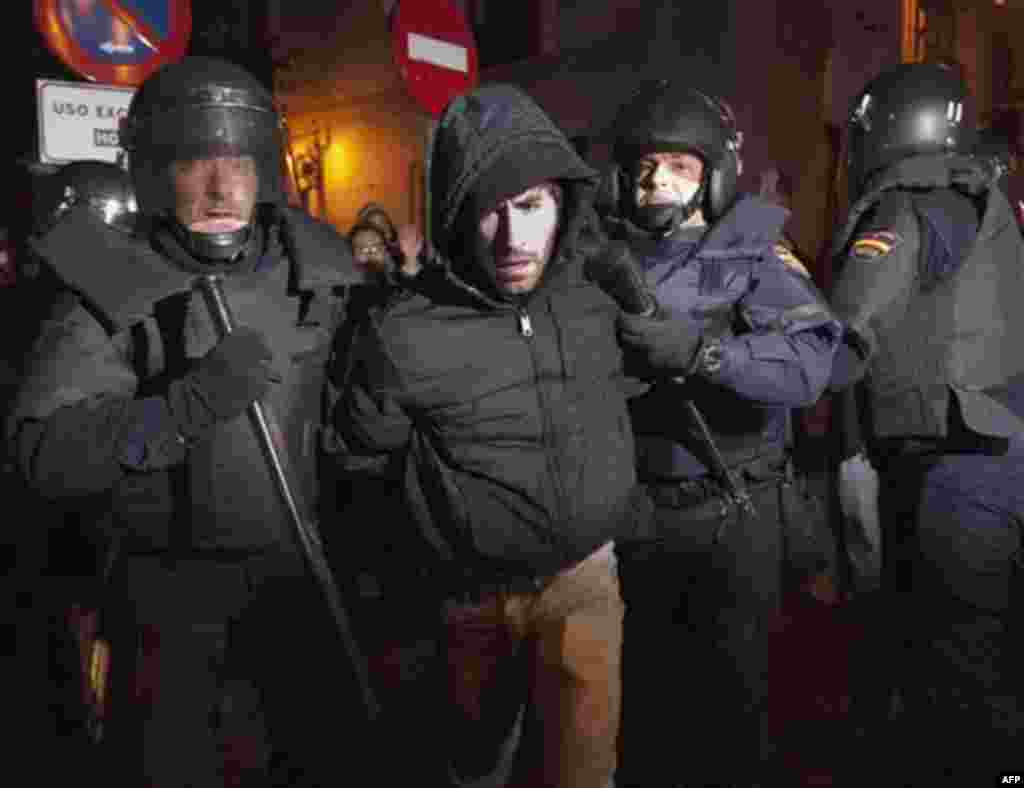 A protester is led away by police officers during a protest against sweeping labor market reforms announced by Spain's new conservative government in Madrid Friday Feb. 10, 2012. The new measures are part of a drive to retool a sick economy and solve Eur