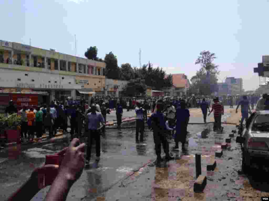 Des pompiers s&#39;activent à éteindre le feu sur trois véhicules endommagés et partiellement incendiés à la suite de l&#39;explosion d&#39;une grenade près de la Banque commerciale du Kenya à Bujumbura, Burundi vendredi 29 mai 2015. (Edward Rwena - VOA)