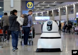 FILE 0 In this April 10, 2017 photo, an LG Electronics cleaning robot moves to clean the floor at the Incheon International Airport in Incheon, South Korea. (AP Photo/Ahn Young-joon)