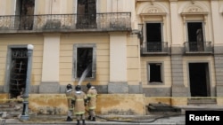 Pemadam kebakaran menyemprotkan air setelah api melalap Museum Nasional Brazil di Rio de Janeiro (4/9). 