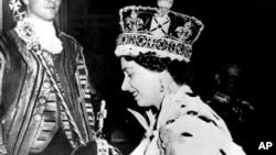 FILE - Britain's Queen Elizabeth II wearing the bejeweled Imperial Crown and carrying the Orb and Scepter with Cross, leaves Westminster Abbey, London, at the end of her coronation ceremony, June 2, 1953.