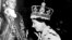 Lady Elizabeth Angela Marguerite Bowes-Lyon, putri Earl of Strathmore ke-14, Duchess of York (kanan) meggendong putri sulungnya, Putri Elizabeth yang lahir tahun 1926 di London, di bawah tatapan penuh kasih suaminya, Duke of York. Pada tahun 1937, Duke of York naik takhta, menjadi George VI setelah saudaranya Edward VIII turun takhta setelah menikahi janda cerai warga Amerika, Wallis Simpson. 