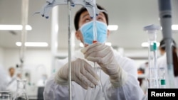 FILE - A man works in a laboratory of a Chinese vaccine maker, developing an experimental coronavirus disease vaccine, in Beijing, China, Sept. 24, 2020. 