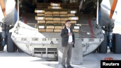 An Afghan security officer stands next to boxes of ammunition inside a Russian aircraft at the International Kabul Airport, Afghanistan, Feb. 24, 2016. 