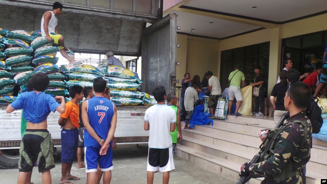 Seorang tentara mengawasi pembongkaran pasokan beras untuk warga yang mengungsi akibat topan Hagupit di kota Tacloban, Filipina (5/12). 
