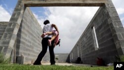 FILE - A woman who is in the country illegally plays with her 2-year-old daughter who was born in the in the United States but was denied a birth certificate, Sullivan City, Texas, Sept. 16, 2015.