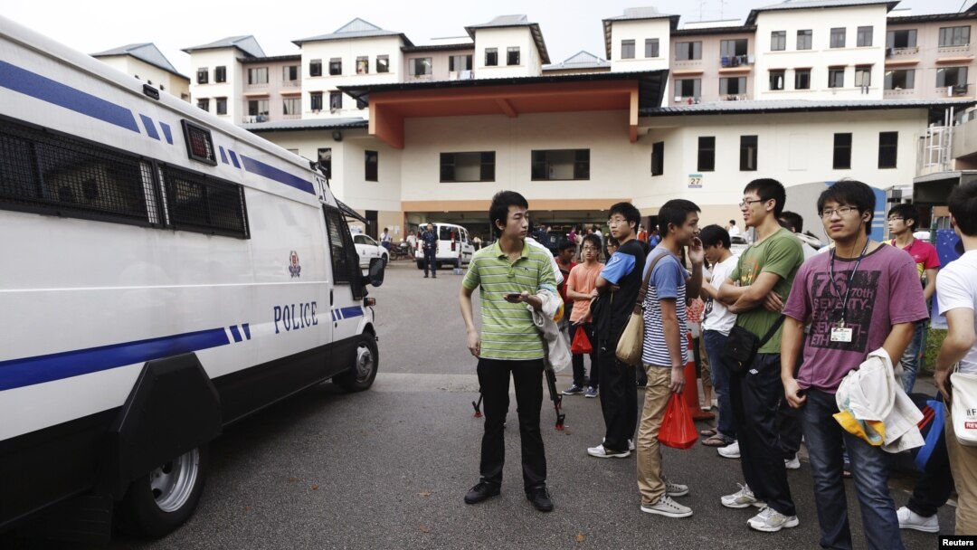 Sebuah van polisi Singapura siaga sementara para sopir bus asal Tiongkok melakukan aksi mogok di Singapura (26/11).