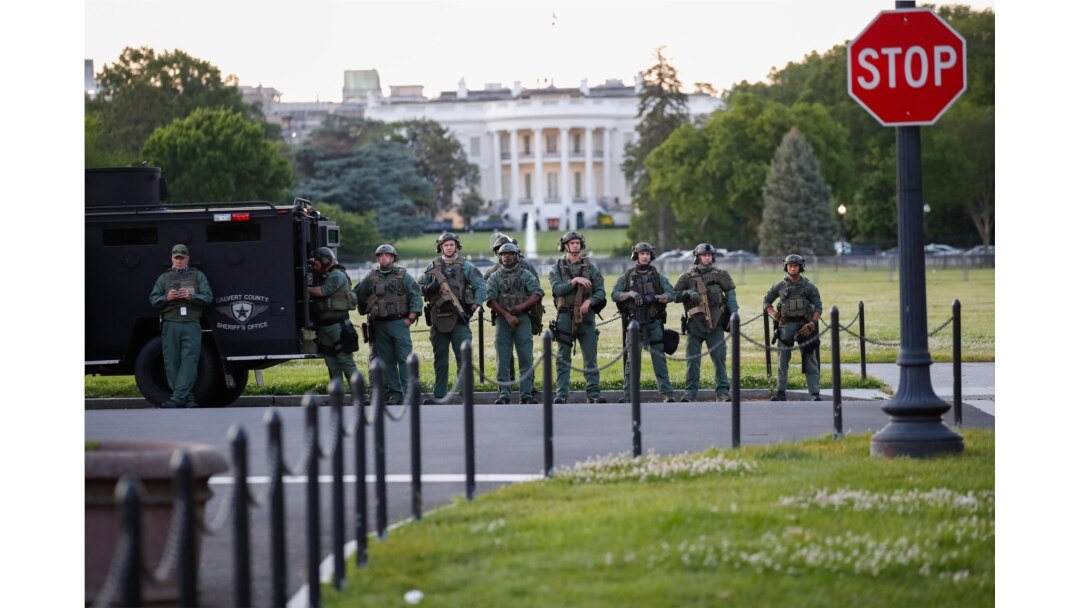 Law enforcement officers from Calvert County Maryland Sheriff's Office standing on the Ellipse, area just south of the White House in Washington, as they watch demonstrators protest