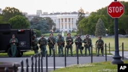 Law enforcement officers from Calvert County Maryland Sheriff's Office standing on the Ellipse, area just south of the White House in Washington, as they watch demonstrators protest