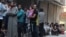 People line up for bread in the rebel-held al-Shaar neighborhood of Aleppo, Syria, July 14, 2016. 