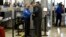 FILE An airline passenger is patted down by a TSA agent after passing through a full-body scanner at Los Angeles International Airport in Los Angeles, California, Feb. 20, 2014. The TSA is under renewed scrutiny as waiting periods for passenger screenings
