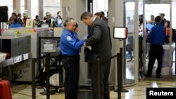 FILE An airline passenger is patted down by a TSA agent after passing through a full-body scanner at Los Angeles International Airport in Los Angeles, California, Feb. 20, 2014. The TSA is under renewed scrutiny as waiting periods for passenger screenings