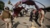 Iraq security forces gather at the site of a suicide bomb attack in Baghdad, Iraq, Oct, 16, 2016. 