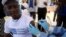 FILE - A World Health Organization (WHO) worker administers a vaccination during the launch of a campaign aimed at beating an outbreak of Ebola in Mbandaka, Democratic Republic of Congo, May 21, 2018. 