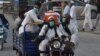 FILE - Pakistani Muslims wearing facemasks as a preventive measure against the COVID-19, arrive for the annual Tablighi Ijtema religious gathering in Raiwind on the outskirts of Lahore on Nov. 5, 2020.