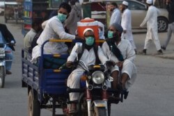 Pakistani Muslims wearing facemasks as a preventive measure against the COVID-19, arrive for the annual Tablighi Ijtema religious gathering in Raiwind on the outskirts of Lahore on Nov. 5, 2020.