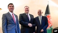 US Secretary of State Mike Pompeo, center, shakes hands with Afghan President Ashraf Ghani, right, as US Secretary of Defense Mark Esper watches during the 56th Munich Security Conference (MSC) in Munich, Feb. 14, 2020. 
