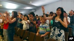 Members of Mawar Sharon Church, which lost about 40 members who were aboard AirAsia Flight 8501, attend a prayer service for the crash victims' relatives, in Surabaya, East Java, Indonesia, Jan. 4, 2015. 