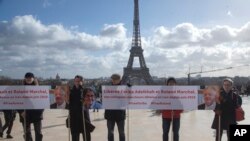 FILE - Activists holding banners at Trocadero square in Paris, France, Feb. 11, 2020, call for the release of scientists Fariba Adelkhah and Roland Marchal, both imprisoned in Iran. Marchal was released earlier this year.