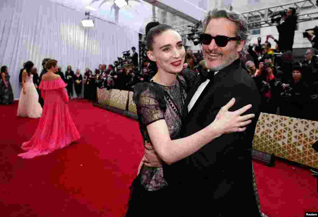 Joaquin Phoenix and Rooney Mara in Alexander McQueen embrace on the red carpet during the Oscars arrivals at the 92nd Academy Awards in Hollywood, Feb. 9, 2020.