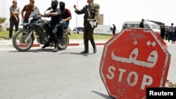 Un policier tunisien passe un point de contrôle à Kairouan, Tunisie, le 18 mai 2013.