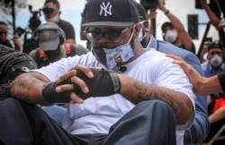 Terrence Floyd sits silently at the spot at the intersection of 38th Street and Chicago Avenue, Minneapolis, Minn., where his brother George Floyd, encountered police and died while in their custody, June 1, 2020.