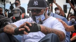 Terrence Floyd sits silently at the spot at the intersection of 38th Street and Chicago Avenue, Minneapolis, Minn., where his brother George Floyd, encountered police and died while in their custody, Monday, June 1, 2020. (AP Photo/Bebeto Matthews)