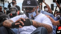 Terrence Floyd sits silently at the spot at the intersection of 38th Street and Chicago Avenue in Minneapolis, Minnesota, where his brother George Floyd encountered police and died while in their custody, June 1, 2020.