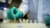 Seorang karyawan perusahaan biofarmasi Jerman CureVac mendemonstrasikan alur kerja penelitian tentang vaksin Covid-19 di laboratorium di Tuebingen, Jerman, 12 Maret 2020. (Foto: Reuters)