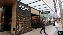 Clientes salen de una tienda Amazon Go, en Seattle, donde se está probando una tecnología libre de contacto, que permitirá a los clientes pagar con simplemente mostrar ante un aparato lector, la palma de la mano.