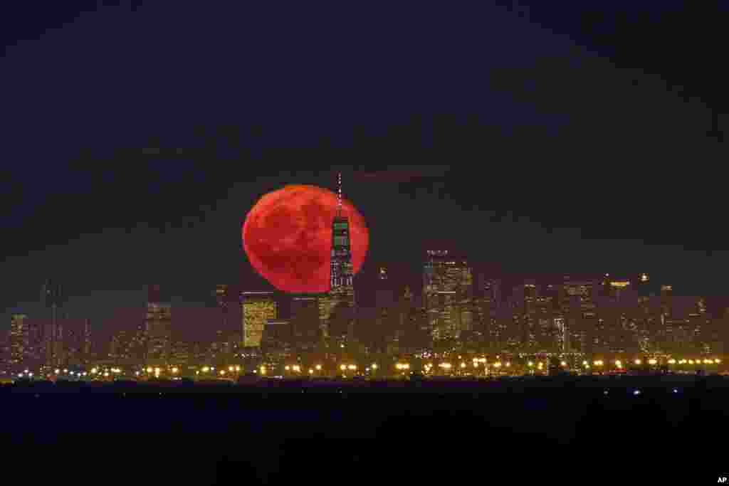 The moon rises behind One World Trade Center on a clear night in Lower Manhattan neighborhood of New York, as seen from Green Brook Township, New Jersey, Oct. 15, 2019.