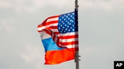 Bendera nasional AS dan Rusia dikibarkan di atas angin di bandara Vnukovo Moskow, Rusia. Rusia pada hari Jumat, 1 September 2017. (Foto: AP)