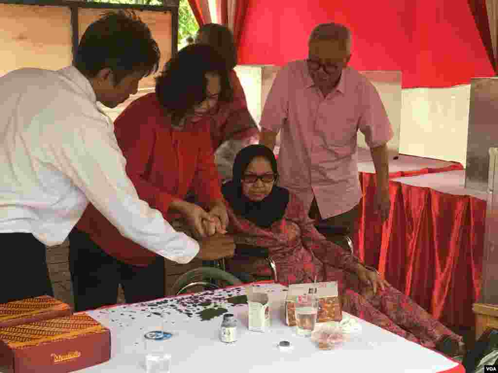 Warga memberikan suaranya dalam pemilihan gubernur Jakarta di TPS Taman Suropati, Jakarta Pusat (15/2). (VOA/Agus Sunarto)