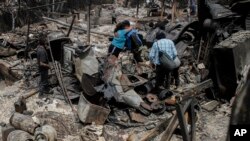 Residentes se abrazan entre los restos de casas calcinadas luego de que incendios forestales alcanzaron su vecindario, el domingo 4 de febrero de 2024, en Viña del Mar, Chile.