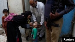 Petugas kesehatan Pakistan memberikan vaksin polio kepada anak-anak di kota Karachi (9/3). 